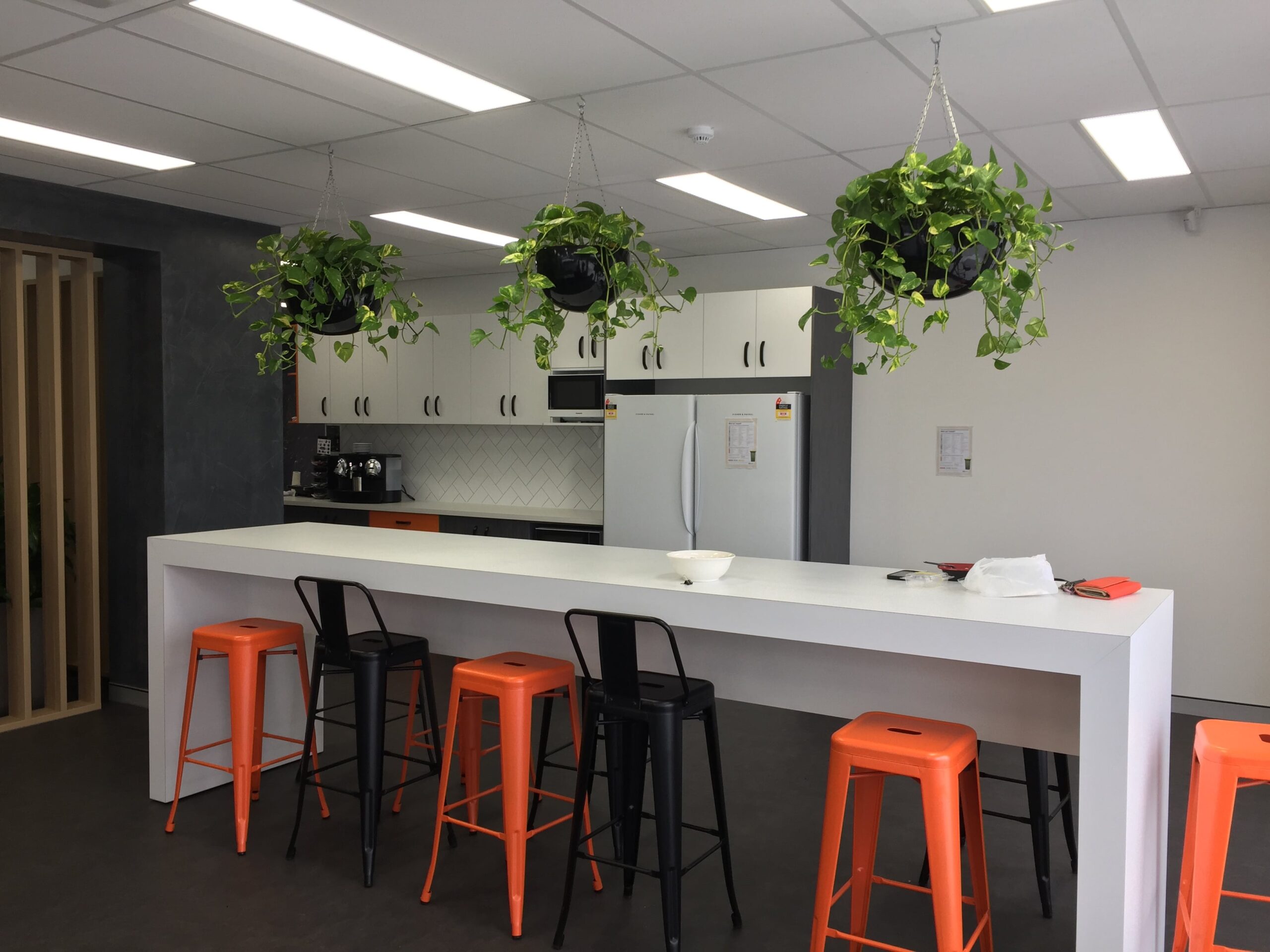 Plats hanging above a bench in a kitchen.